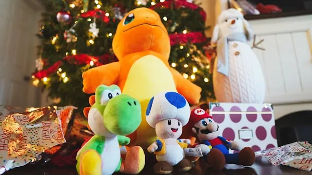 four christmas plush toys in front of christmas tree